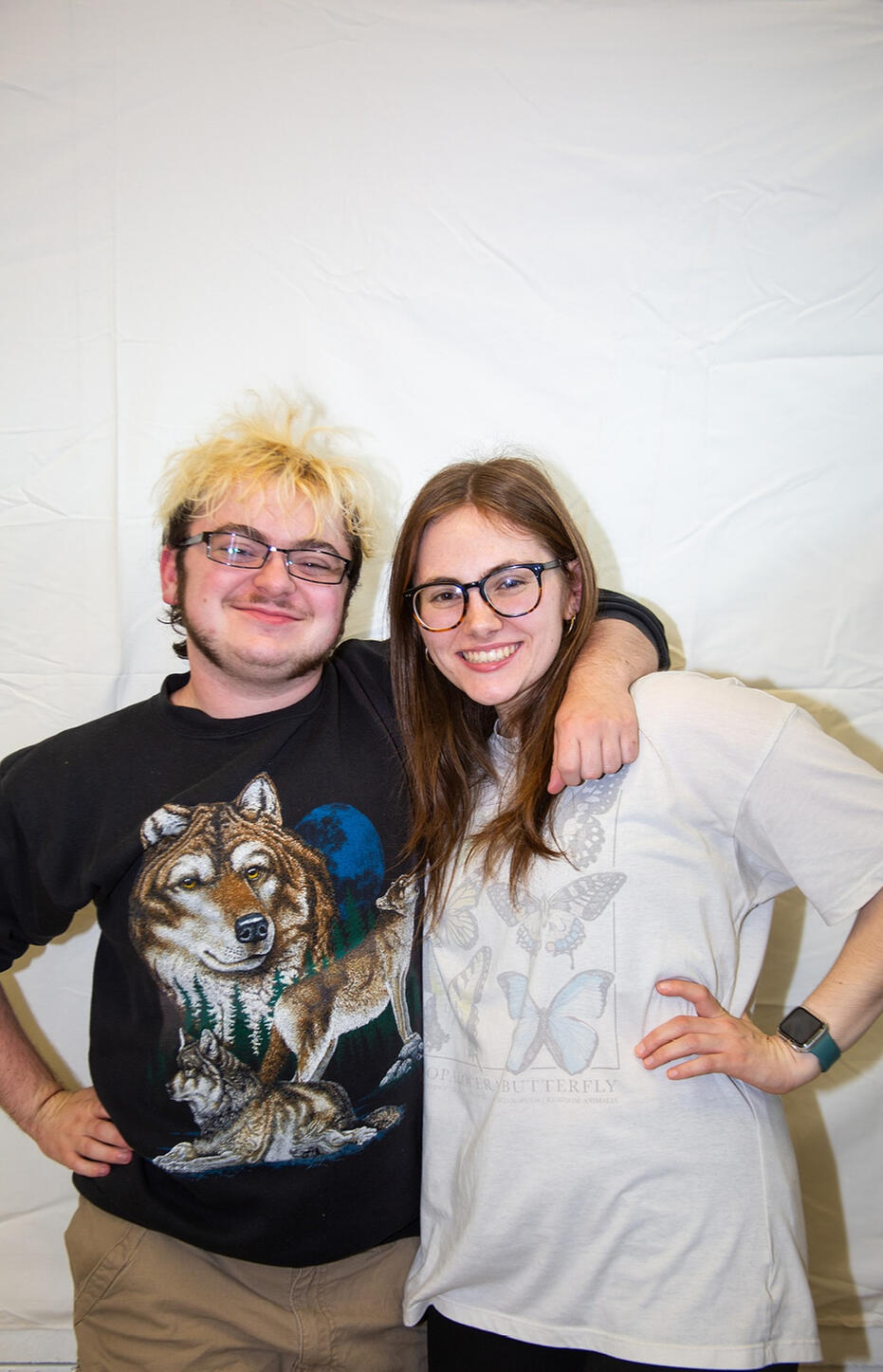 Lyle O Lewis and Jolie Greco standing next to each other, both with a hand on their hip and arm around the other
